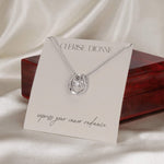 Abundance pendant wrapped around a necklace holder card in front of an elegant gift box. The card features the Cherise Dionne logo and the phrase 'express your inner radiance'.