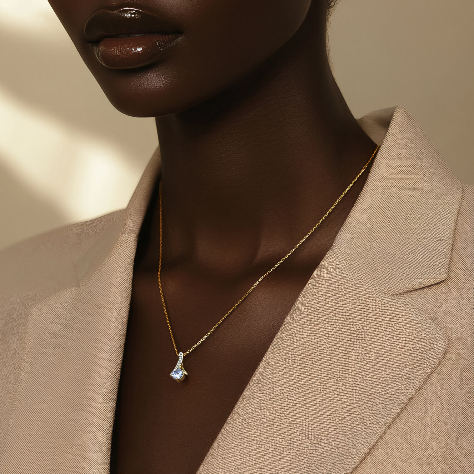 Model wearing the Allure necklace in 18k gold finish with a beige blazer. The delicate chain glimmers in the soft, natural light.