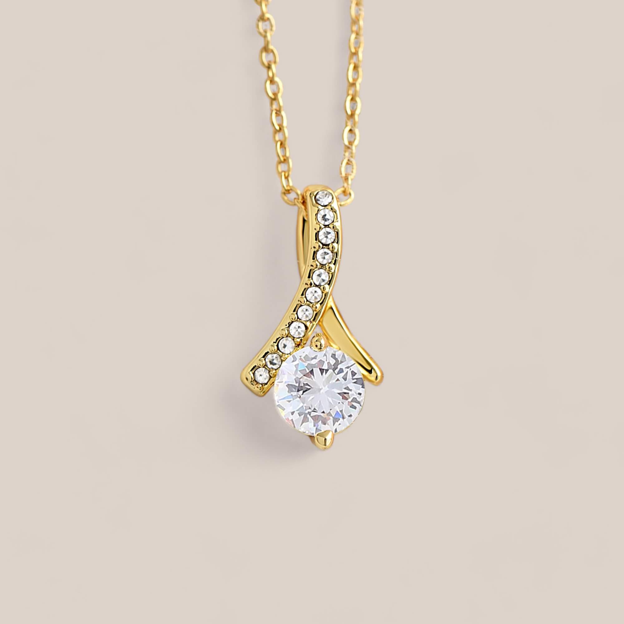 18k gold-plated Allure necklace featuring a round-cut cubic zirconia crystal suspended from a dainty ribbon-shaped pendant with tiny crystals embedded along one side.