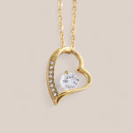 18k gold-plated Passion necklace featuring an asymmetrical heart-shaped design with embedded crystals along the side of the heart and a round-cut cubic zirconia crystal in the center.