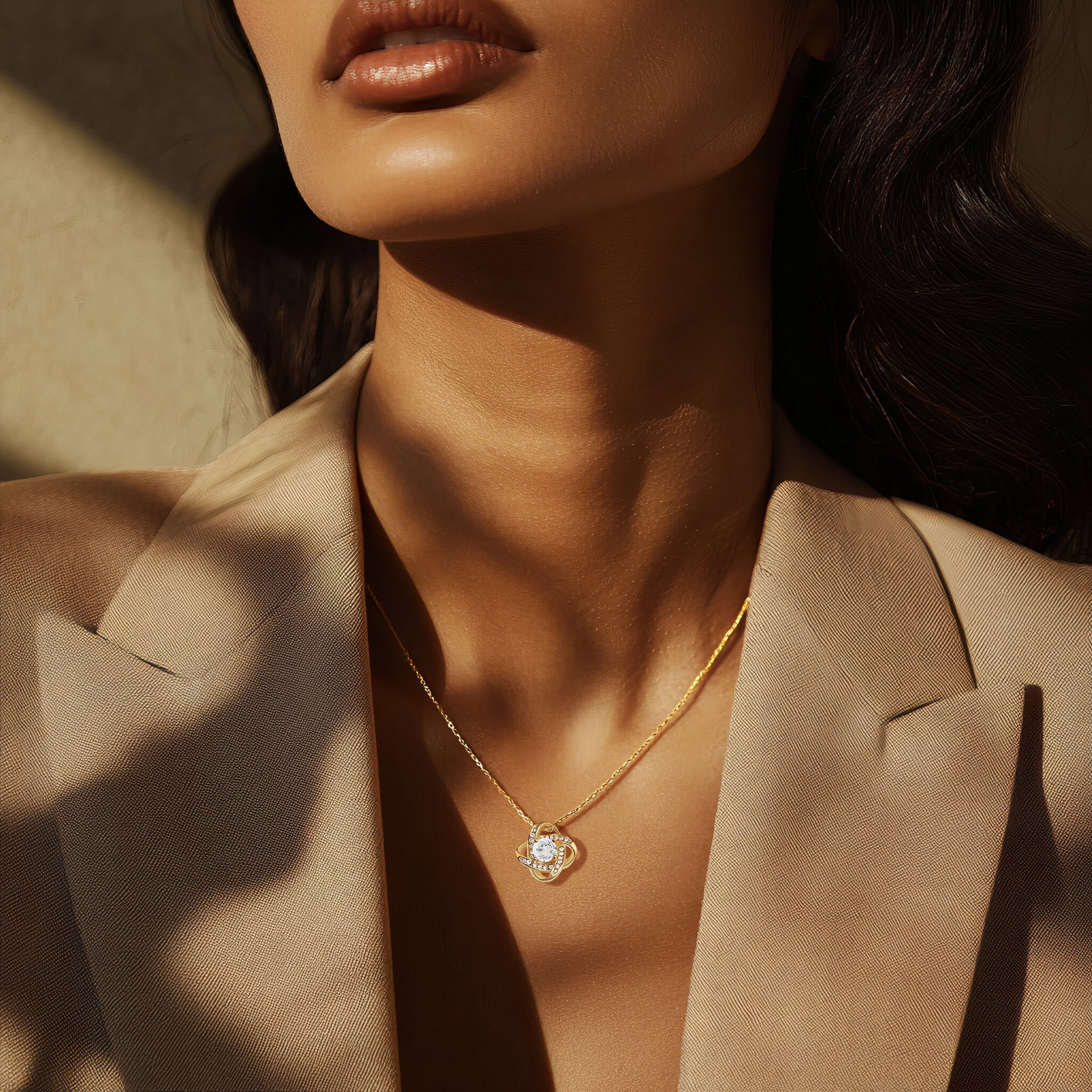 Model wearing Radiance necklace in 18k gold finish with a beige blazer in natural sunlight, showcasing the sparkle of the delicate chain and pendant.