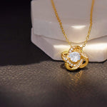 Radiance pendant necklace in 18k gold finish draped across two marble discs in sunlight